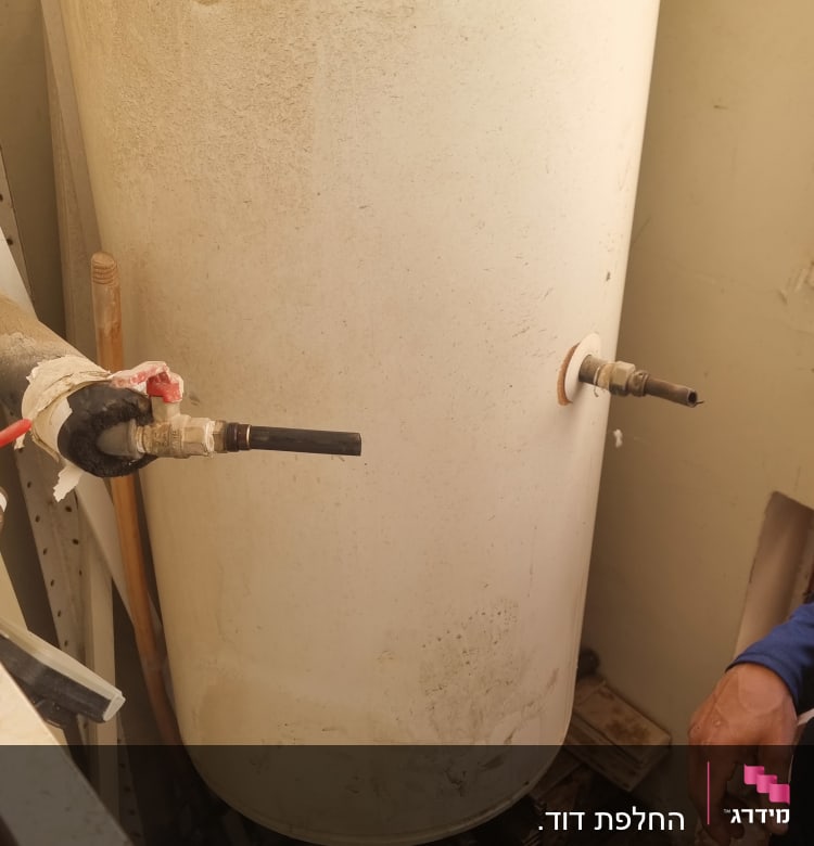 דוד שמש עם צינורות מחוברים בחדר קטן